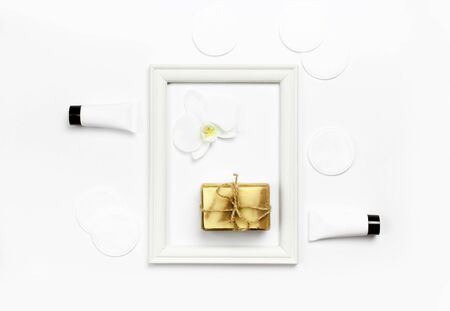 White cosmetic bottle containers, natural soap, orchid flower on white background top view flat lay. Cosmetics SPA branding mock-up.の写真素材
