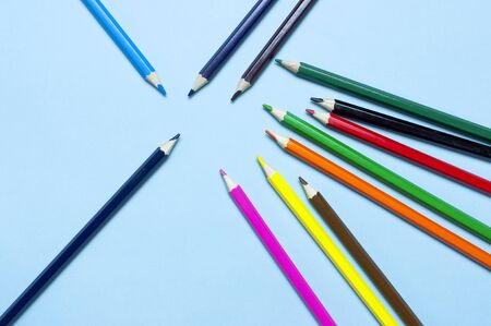 Back to school concept. Color pencils on blue background top view flat lay with copy space. Wooden colored pencils for drawing, objects for creativity, school supplies close-up.の写真素材