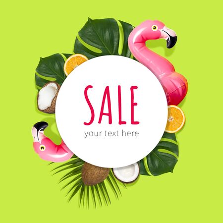 Creative concept of summer sales. Inflatable pink mini flamingo tropical palm leaf monstera coconut orange on green background pool float party. Flat lay Flamingo Trend Inflatable Toy. Discounts, sale.の写真素材