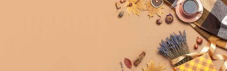 Autumn Flat lay composition. Cup of tea, autumn dry leaves, roses flowers, lavender, gift bag cones decorative pomegranate cinnamon sticks on brown pink background top view. Autumn, fall concept.の写真素材