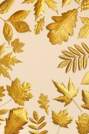 Flat lay creative autumn composition. Frame from Golden leaves on beige background top view copy space. Fall concept. Autumn background. Minimal concept idea, floral design.の写真素材