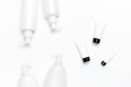 White cosmetic bottle containers on white background top view flat lay with space for text. Cosmetics SPA branding mock-up, Natural organic beauty product concept, Minimalism cosmetics style.の写真素材