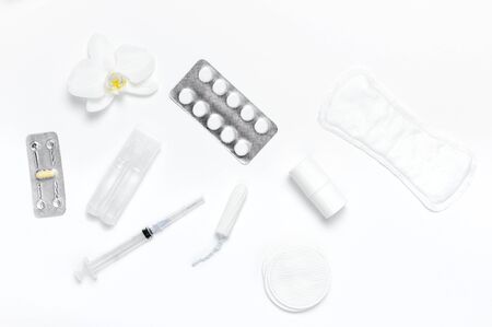 Spa concept cosmetology medicine plastic surgery branding mock-up. White cosmetic bottle syringe hygiene items gasket tampon cotton pads injections tablet orchid on white background flat lay.の写真素材