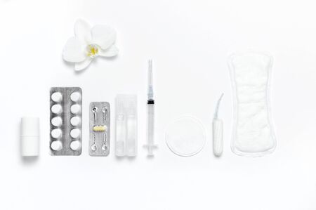 Spa concept cosmetology medicine plastic surgery branding mock-up. White cosmetic bottle syringe hygiene items gasket tampon cotton pads injections tablet orchid on white background flat lay.の写真素材