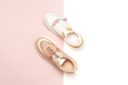 Different female sneakers on white pink background. Fashion blog or magazine concept. Women's shoes, trendy sneakers, fashion, style, lifestyle. Flat lay top view copy space minimal background.の写真素材