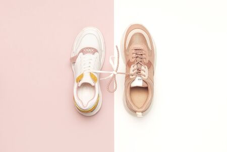 Different female sneakers on white pink background. Fashion blog or magazine concept. Women's shoes, trendy sneakers, fashion, style, lifestyle. Flat lay top view copy space minimal background.の写真素材