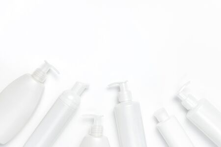 White cosmetic bottle containers on white background top view flat lay with space for text. Cosmetics SPA branding mock-up, Natural organic beauty product concept, Minimalism cosmetics style.の写真素材