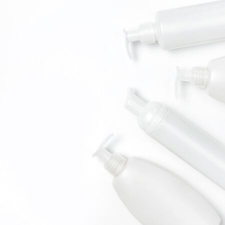 White cosmetic bottle containers on white background top view flat lay with space for text. Cosmetics SPA branding mock-up, Natural organic beauty product concept, Minimalism cosmetics style.の写真素材