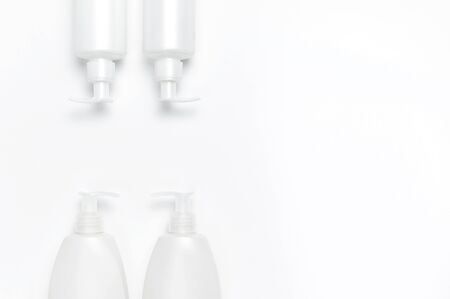 White cosmetic bottle containers on white background top view flat lay with space for text. Cosmetics SPA branding mock-up, Natural organic beauty product concept, Minimalism cosmetics style.の写真素材