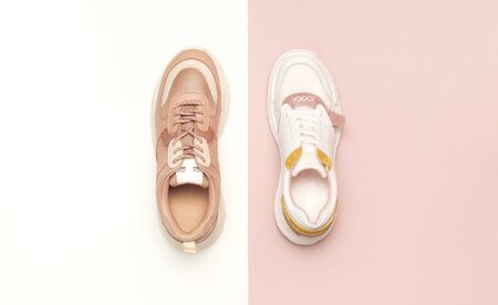 Different female sneakers on white pink background. Fashion blog or magazine concept. Women's shoes, trendy sneakers, fashion, style, lifestyle. Flat lay top view copy space minimal background.の写真素材