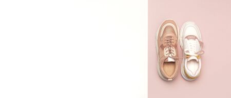 Different female sneakers on white pink background. Fashion blog or magazine concept. Women's shoes, trendy sneakers, fashion, style, lifestyle. Flat lay top view copy space minimal background.の写真素材