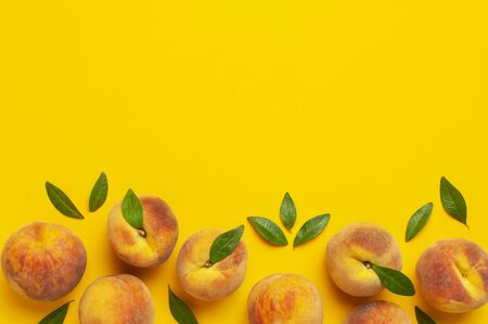 Flat lay composition with peaches. Ripe juicy peaches with green leaves on yellow background. Flat lay, top view, copy space. Fresh organic fruit, vegan food. Harvest concept.の写真素材