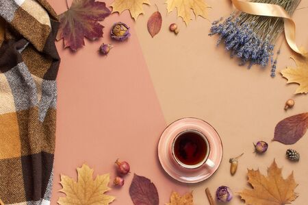 Autumn Flat lay composition. Cup of tea, checkered cozy plaid, lavender on pink beige background top view copy space. Fall concept. Autumn cozy home morning, autumn background. Hot drink, herbal tea.の写真素材