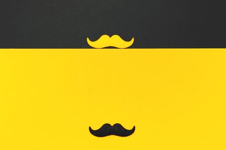 Creative party decoration concept. Black and yellow mustache, props for photo booths, carnival parties on black yellow background top view flat lay copy space Father's day Men's health awareness month.の写真素材