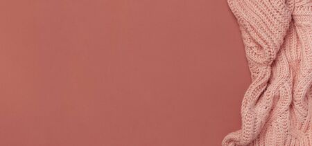 Flat lay autumn composition. Knitted woolen pink female sweater or plaid on burgundy brown background top view copy space. Fall concept. Fashion color, fashionable cozy autumn thing, clothes.の写真素材