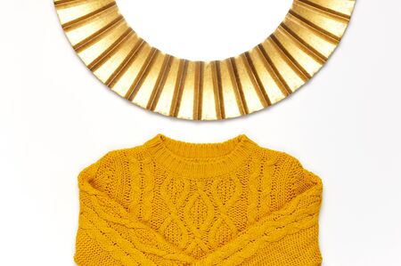 Fashionable vintage modern golden frame, knitted orange sweater isolated on white background. Photo frame, mirror frame, baguette, stylish interior item. Autumn, fall concept.の写真素材