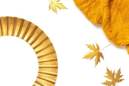 Fashionable vintage modern golden frame, knitted orange sweater, golden autumn leaves isolated on white background. Photo frame, mirror frame, baguette, stylish interior item. Autumn, fall concept.の写真素材