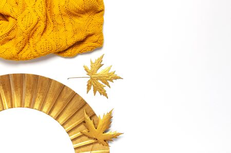 Fashionable vintage modern golden frame, knitted orange sweater, golden autumn leaves isolated on white background. Photo frame, mirror frame, baguette, stylish interior item. Autumn, fall concept.の写真素材