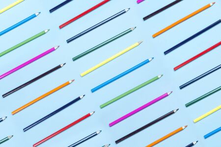 Color pencils on pastel blue background top view flat lay with copy space. Wooden colored pencils for drawing, objects for creativity, school supplies close-up. Back to school concept.の写真素材