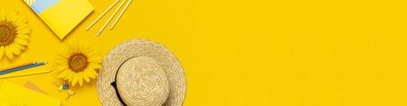 Top view flat lay of workspace desk styled design with sunflowers, straw hat, notebook, diary, pencils, pen scissors on bright yellow background. Autumn or summer Concept. Sunflower natural background.の写真素材