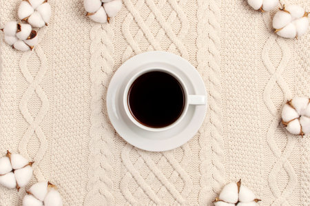 Flat lay autumn composition. Cup of coffee, knitted woolen light beige sweater or plaid, cotton...