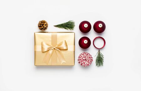 New Year Christmas composition. Golden presents with ribbon red Christmas balls pine branches cone on gray background top view. Gift boxes Festive decorations. Flat lay Xmas holiday 2020 celebration.の写真素材