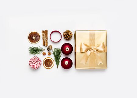 New Year Christmas composition. Golden presents with ribbon red Christmas balls pine branches cone on gray background top view. Gift boxes Festive decorations. Flat lay Xmas holiday 2020 celebration.の写真素材