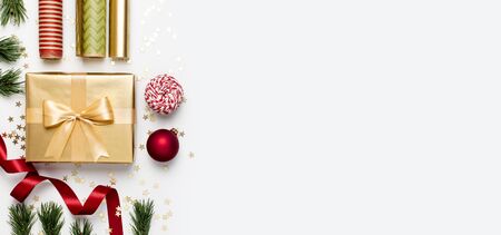 Flat lay Xmas holiday 2020 celebration. New Year Christmas golden presents with ribbon red Christmas balls pine branches gold confetti stars on gray background top view. Gift boxes Festive decorations.の写真素材