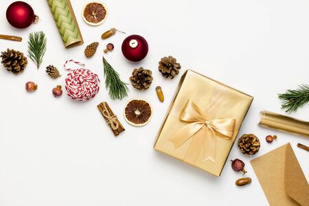 Flat lay Xmas holiday 2020 celebration. New Year Christmas golden presents with ribbon red Christmas balls pine branches gold confetti stars on gray background top view. Gift boxes Festive decorations.の写真素材