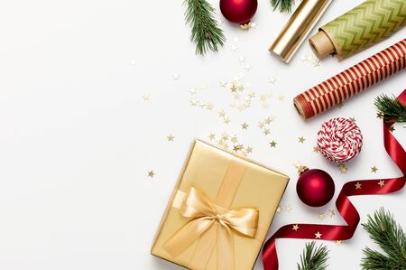 Flat lay Xmas holiday 2020 celebration. New Year Christmas golden presents with ribbon red Christmas balls pine branches gold confetti stars on gray background top view. Gift boxes Festive decorations.の写真素材