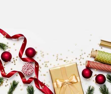 Flat lay Xmas holiday 2020 celebration. New Year Christmas golden presents with ribbon red Christmas balls pine branches gold confetti stars on gray background top view. Gift boxes Festive decorations.の写真素材