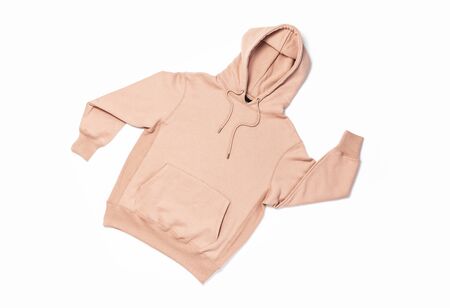 Female peach pink sweatshirt with pocket and hood isolated on white background. Fashionable women's clothing, hoody, casual youth style, sports. Autumn fashion.の写真素材