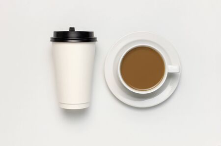 Coffee or tea paper cup, white cup with coffee on light gray background top view flat lay copy space. Take away coffee cup, mockup. Minimal composition, layout for design.の写真素材