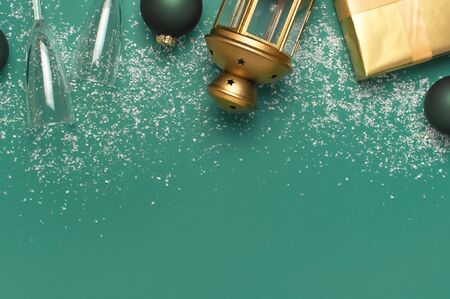 New Year Christmas presents, Christmas balls, champagne glasses, gold confetti stars on green background top view. Flat lay Xmas holiday 2020 celebration. Gift boxes greeting card Festive decorations.の写真素材
