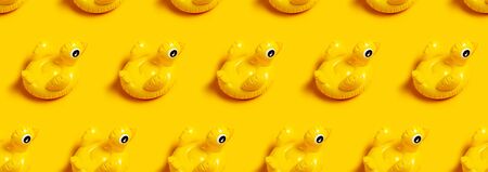 Creative summer beach concept. Seamless Pattern of Inflatable mini yellow chicken or duckling on yellow background, pool float party. Flat lay copy space. Trend Inflatable Children toy for swimming.の写真素材