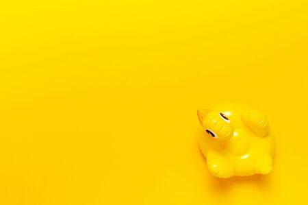Creative summer beach concept. Inflatable mini yellow chicken or duckling on yellow background, pool float party. Flat lay copy space. Trend Inflatable Children toy for swimming. Layout for design.の写真素材