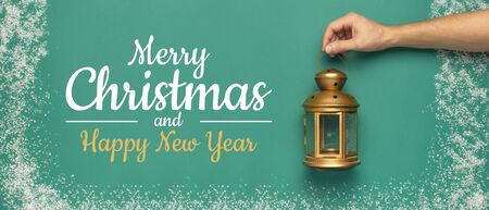 New Year Christmas presents, holiday flashlight in male hands on green background with snow frame top view copy space. Flat lay Xmas holiday 2020 celebration. Gift boxes greeting card Festive decor.の写真素材