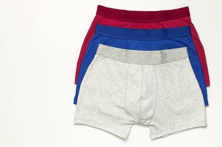 Men's underwear, set of multi-colored underpants on white background flat lay top view copy space. Fashion blog, natural underwear, advertising, shopping concept. Pants boxers.の写真素材