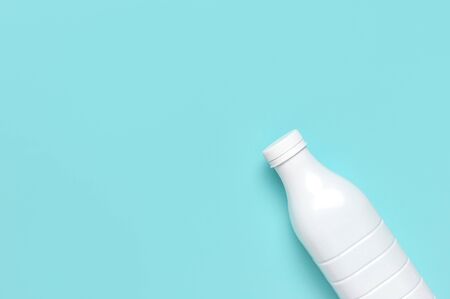 White plastic bottle containers for dairy products on blue turquoise background top view flat lay. Plastic Kefir Yogurt Milk Bottle. Packaging template mockup. Layout for your design.の写真素材