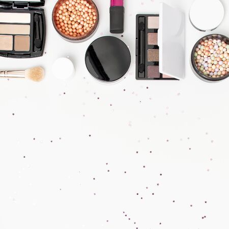 Set of decorative cosmetics mascara powder lipstick eyeshadow blush makeup brush, star confetti on light background top view Flat lay. Beauty blogger concept. Fashion background. Makeup.の写真素材