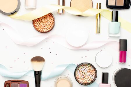 Set of decorative cosmetics mascara powder lipstick eyeshadow blush makeup brush, star confetti holiday ribbons on light background top view Flat lay. Beauty blogger concept. Fashion background Makeup.の写真素材