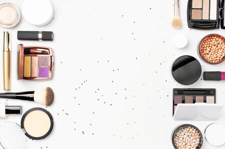 Set of decorative cosmetics mascara powder lipstick eyeshadow blush makeup brush, star confetti on light background top view Flat lay. Beauty blogger concept. Fashion background. Makeup.の写真素材