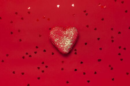 Heart Shaped Macaroon Cake and confetti on red background top view Flat lay. Creative composition for Valentine's Day, love concept, birthday present, mother day, holiday background. Love for sweets.の写真素材