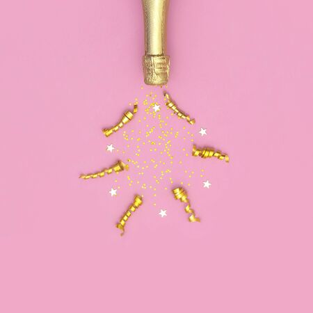 Christmas and New Year background. Champagne bottle, festive golden ribbons and star confetti on pink background top view. Flat lay holiday card. Birthday or wedding concept. Festive decorations 2020.の写真素材
