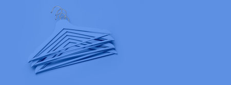 Creative fashion concept. Flat lay top view wooden hangers minimalism style. Sale discount store shopping concept, design empty hanger. Beauty feminine blog. Color of the year 2020 classic blue.の写真素材