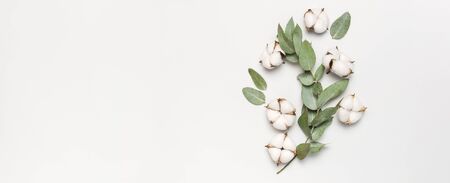 Flat lay flowers composition. Cotton flowers and fresh eucalyptus twigs on light gray background. Top view, copy space. Delicate white cotton flowers. Floral background, greeting card.の写真素材