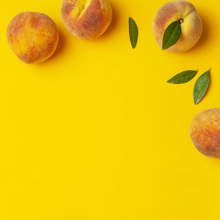 Flat lay composition with peaches. Ripe juicy peaches with green leaves on yellow background. Flat lay, top view, copy space. Fresh organic fruit, vegan food. Juicy Fruit Background.の写真素材