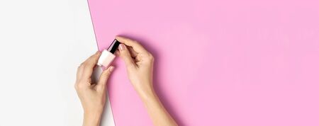 Stylish beautiful gentle manicure. Hands of young woman on pink background top view flat lay copy space. Natural nails, gel polish, self-care, beauty and fashion. Nail care, Beauty salon advertisement.の写真素材