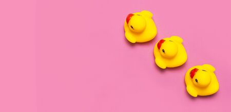 Trend Inflatable Children toy for swimming. Inflatable Three yellow chicken or duckling on pink background, pool float party. Flat lay copy space. Creative summer beach concept. Layout for design.の写真素材