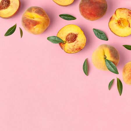 Summer fruit background. Flat lay composition with peaches. Ripe juicy peaches with green leaves on pink background. Flat lay top view copy space. Fresh organic fruit vegan food. Harvest concept.の写真素材